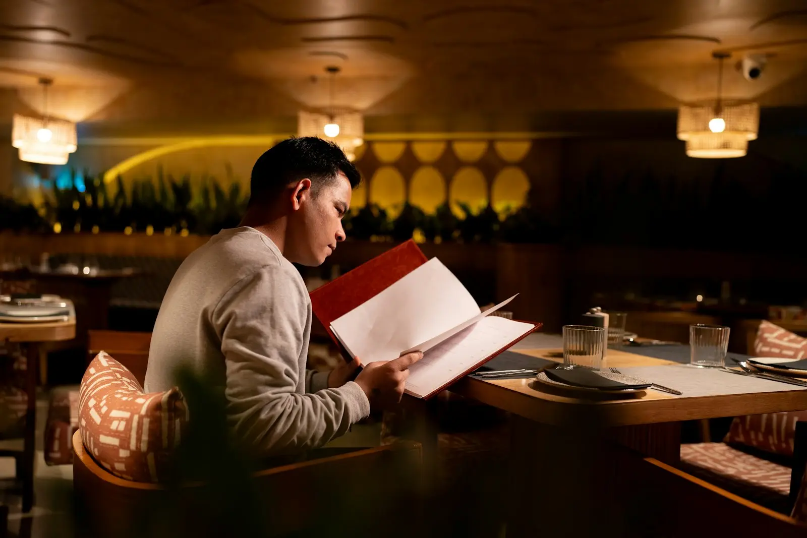 A guest reading the menu at a softly lit table